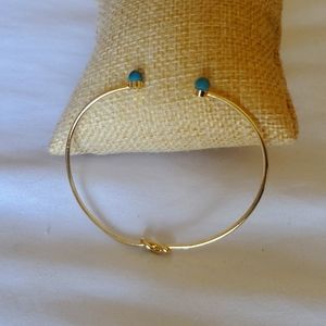 bangle with a knot in one site and turquoise marbles in the other